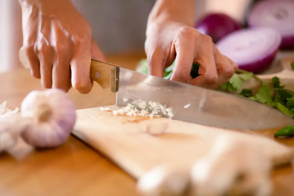 Chef cutting vegetables evenly on a board demonstrating ingredient preparation in cooking