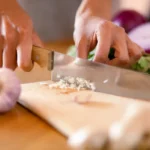 Chef cutting vegetables evenly on a board demonstrating ingredient preparation in cooking
